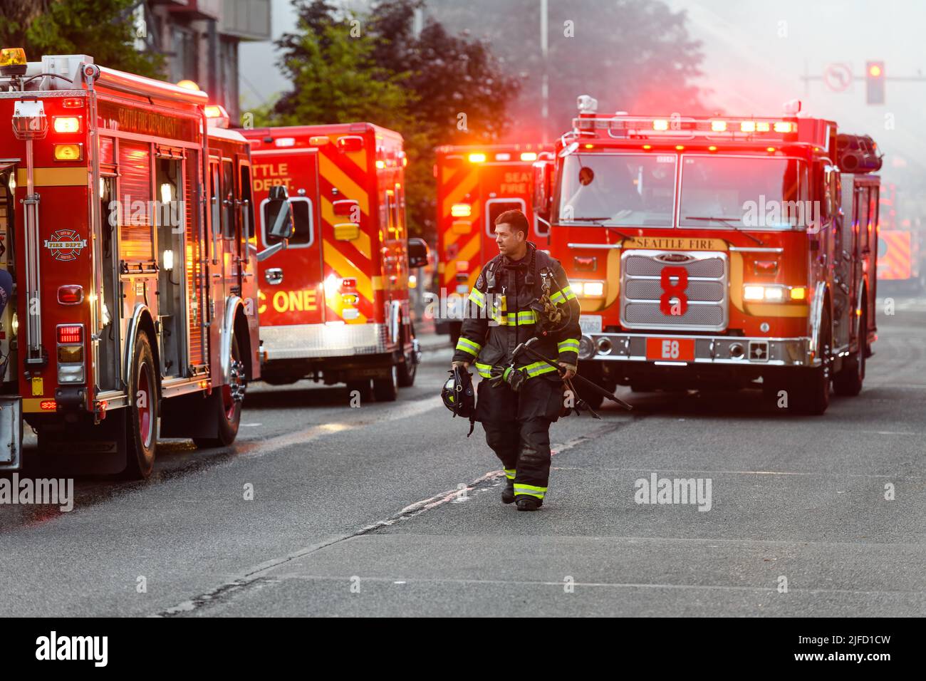 Seattle - 30 giugno 2022; Firefighter cammina accanto ai veicoli di emergenza alla fine della chiamata per contenere un allarme due Blaze nel quartiere Belltown di Seattle Foto Stock