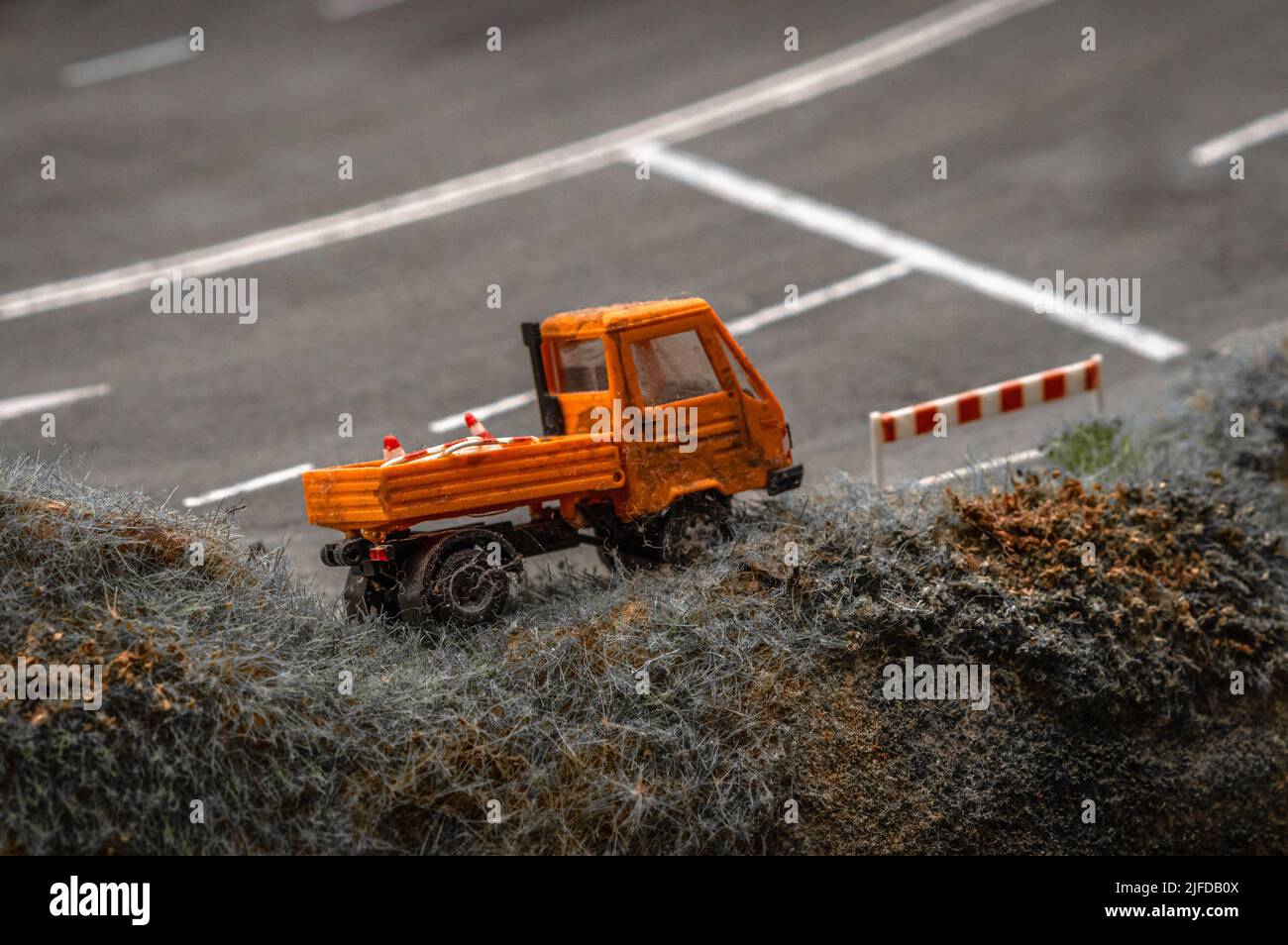 Rappresentazione giocattolo di un carrello giallo per la manutenzione della strada. Foto Stock