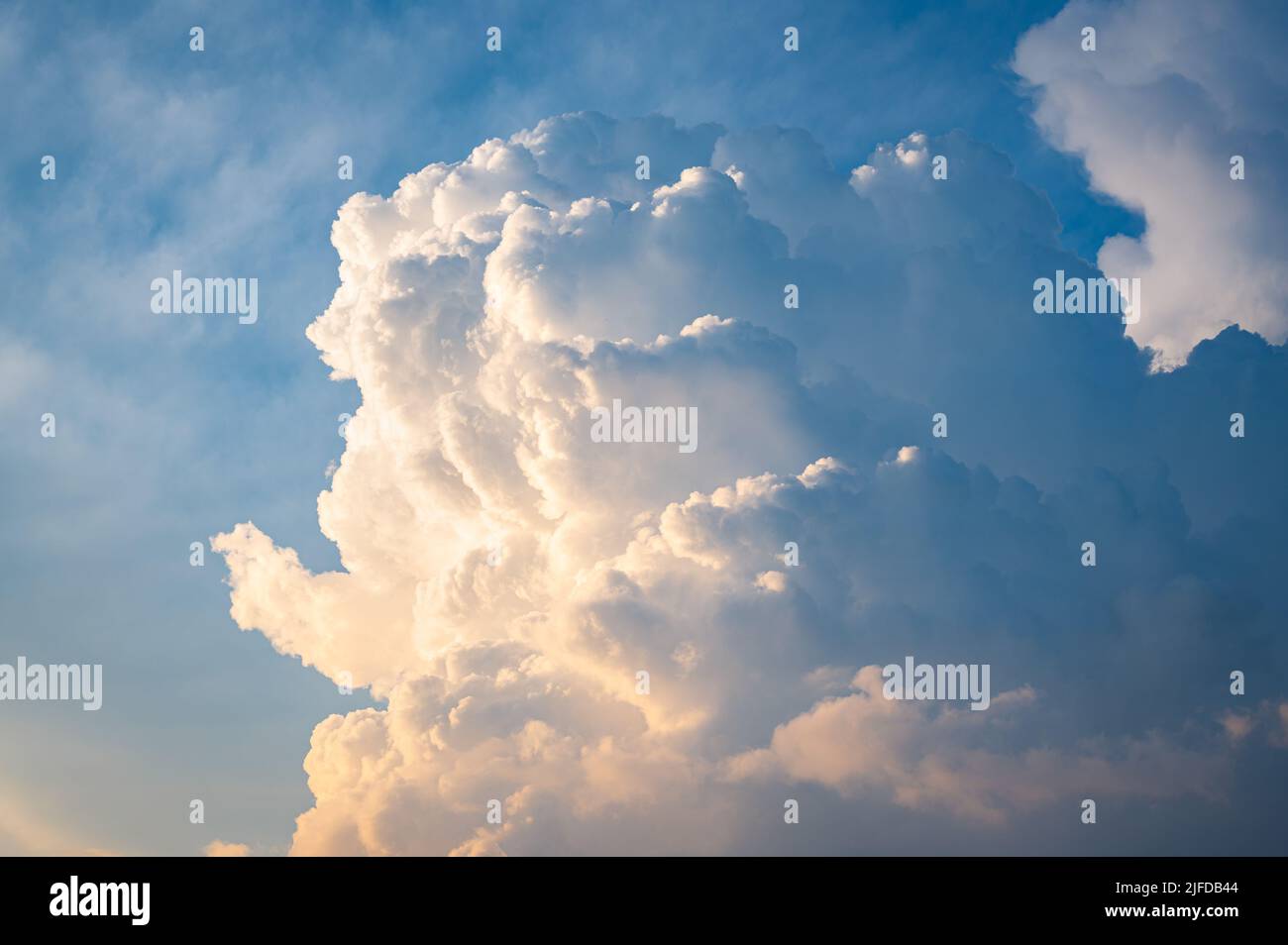 Cima di una nube di tempesta Cumulonimbus illuminata dal sole basso Foto Stock