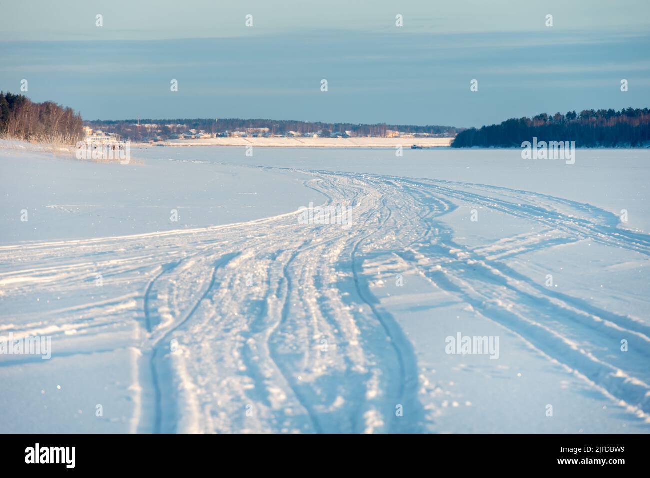 Tracce di veicoli e persone sul fiume Volga ghiacciato e innevato Foto Stock