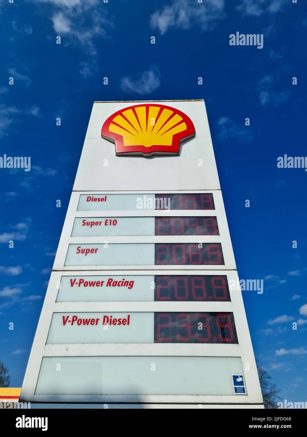 La visualizzazione del prezzo della benzina della stazione di benzina Shell contro il cielo blu Foto Stock