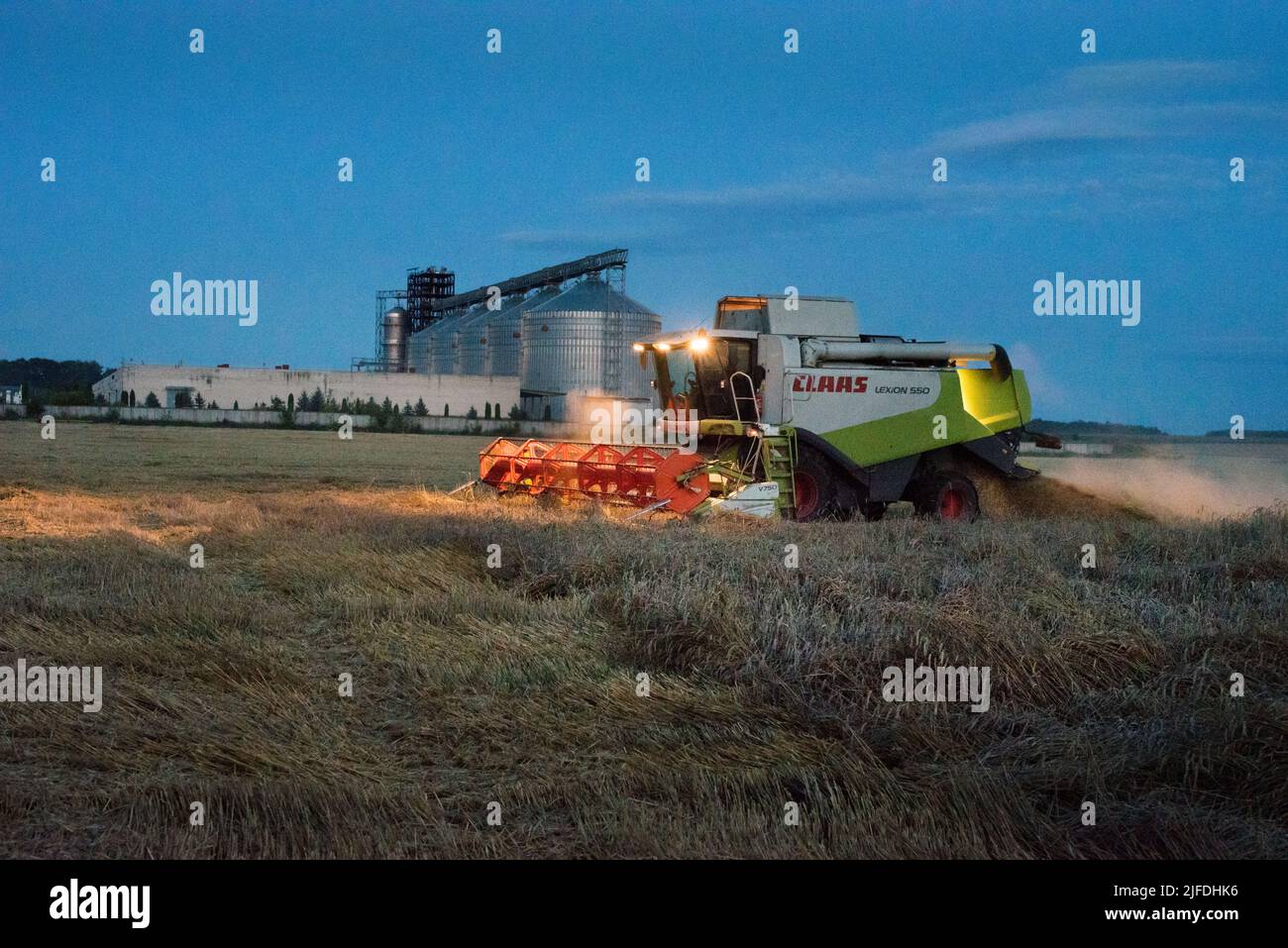 REGIONE DI TERNOPIL, UCRAINA - 03 agosto 2021: - Combinare lavoro CLAAS di notte nel campo del grano, la raccolta Foto Stock