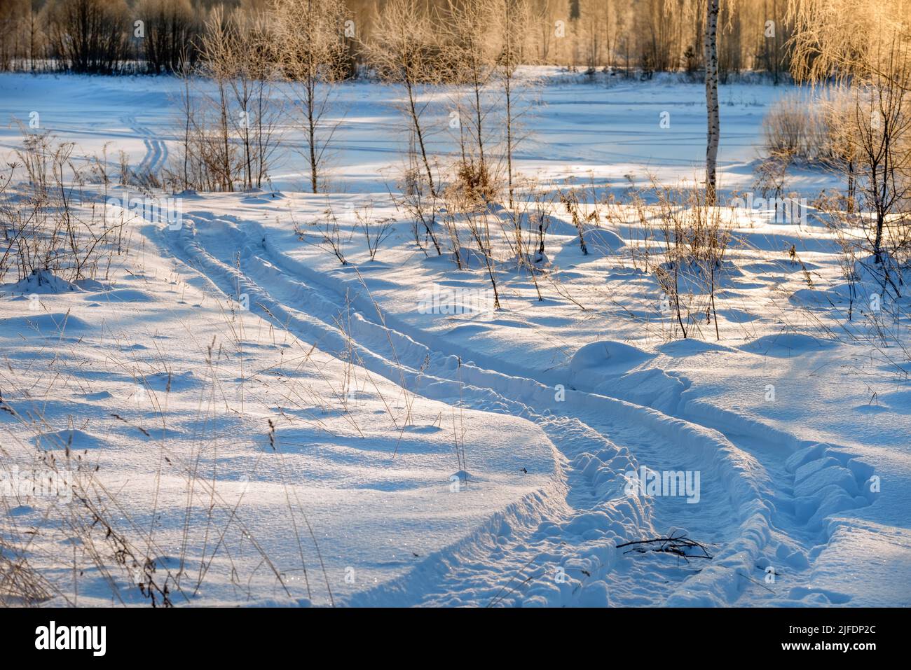 Tracce di veicoli e persone sul fiume Volga ghiacciato e innevato Foto Stock