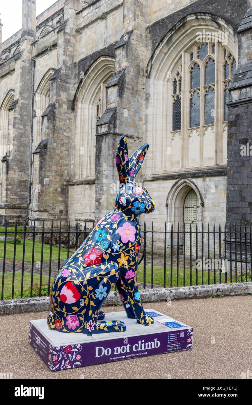 Hares of Hampshire Art Trail nel centro di Winchester durante l'estate 2022, Inghilterra, Regno Unito. Colorata scultura di lepre di fronte alla Cattedrale di Winchester. Foto Stock