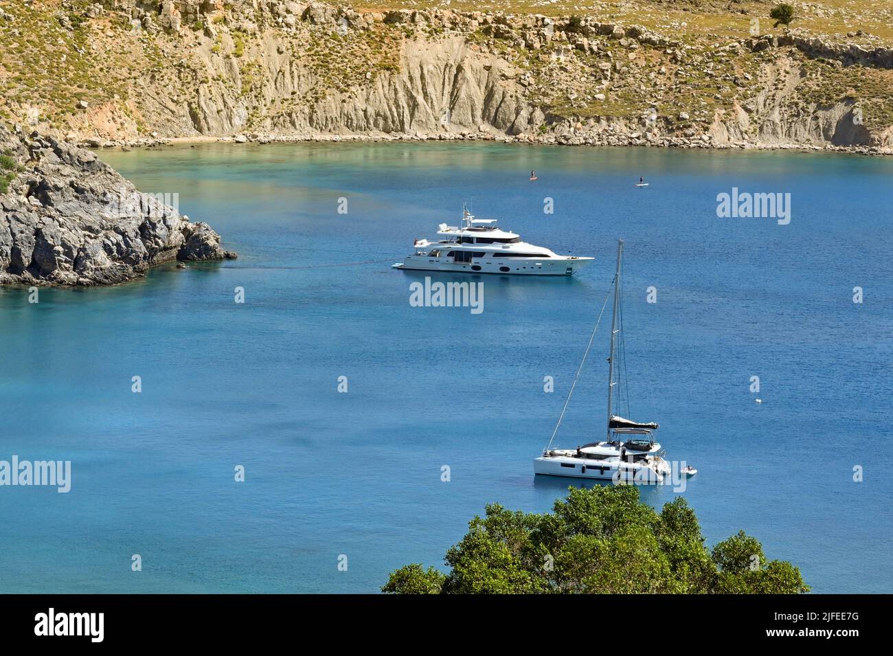 Lindos, Rhodes, Grecia - Maggio 2022: Vista aerea delle barche di lusso ormeggiate nella baia al largo della spiaggia della città Foto Stock