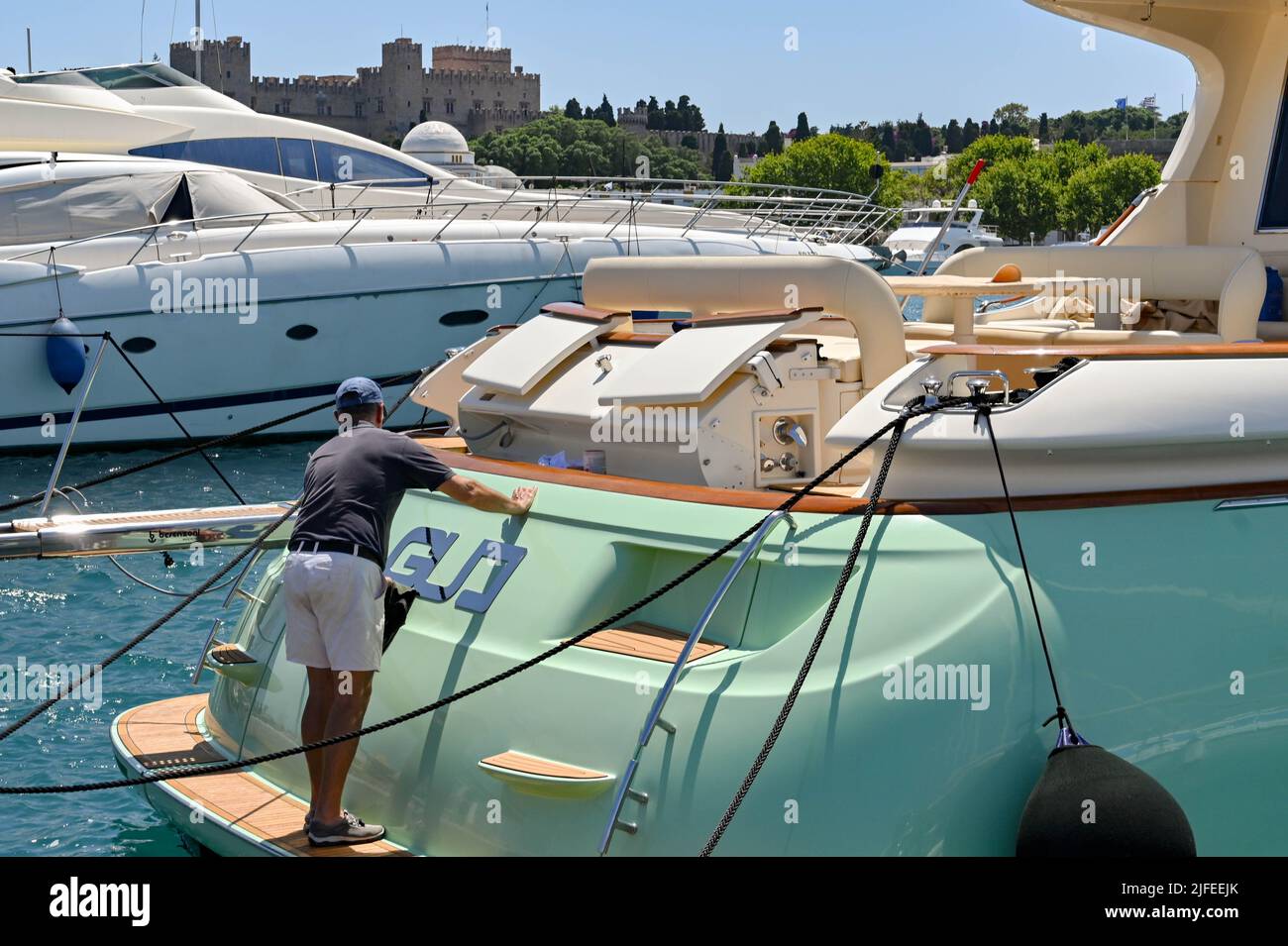 Rodi, Grecia - Maggio 2022: Persona che lucida la parte posteriore di un yacht a motore di lusso Foto Stock