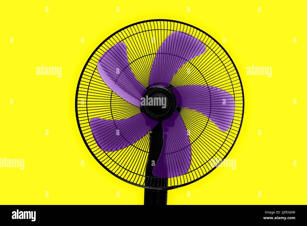 ventola nera con pale viola e sfondo giallo Foto Stock