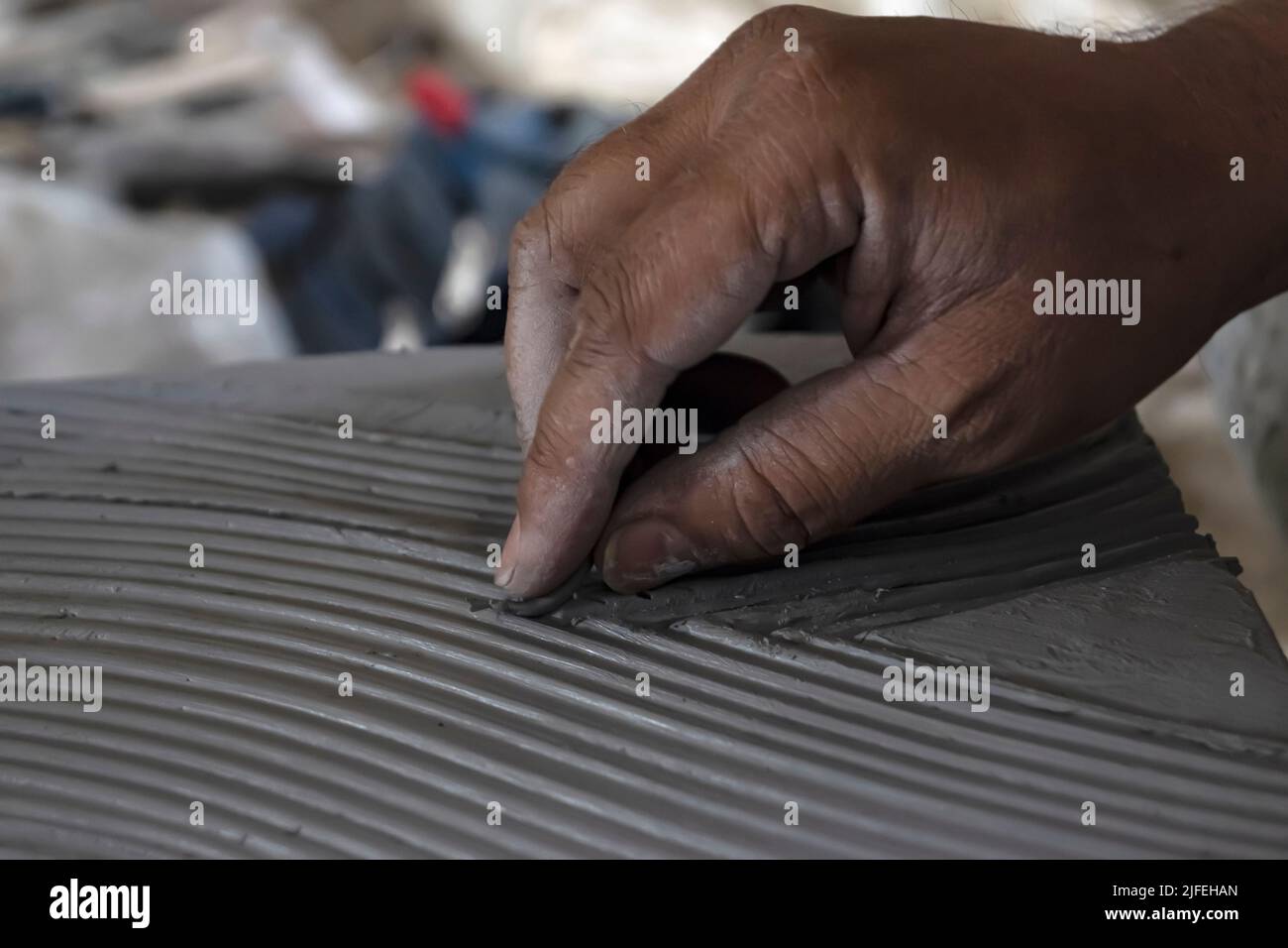 Primo piano dello scultore maschile che fa arte su argilla usando le mani. Matrice di stampaggio di creta. Modellazione di argilla. Foto Stock
