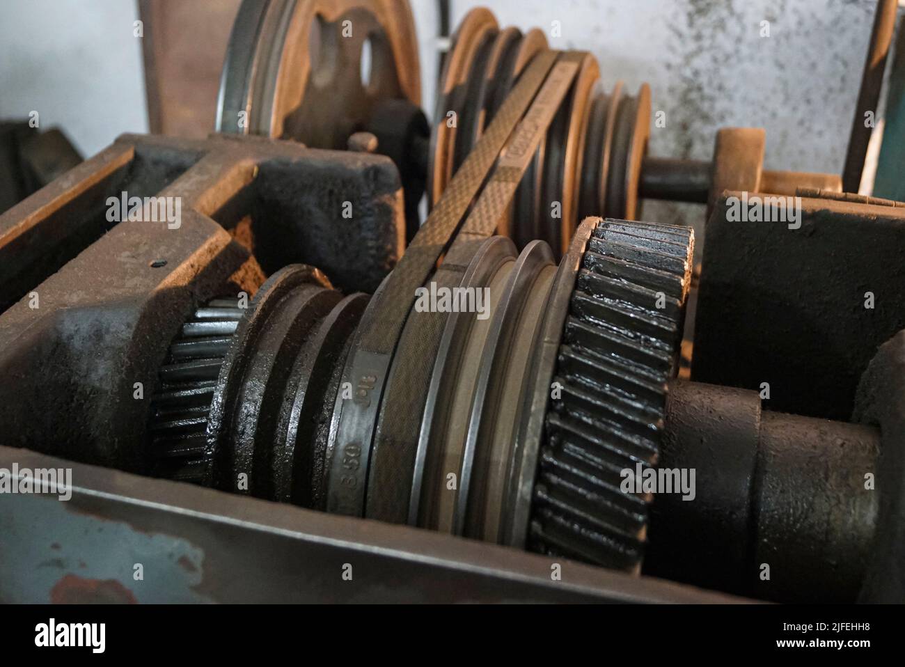 Primo piano di ingranaggi in metallo oleoso e cinghia di vecchio tornio Machinery. Foto Stock