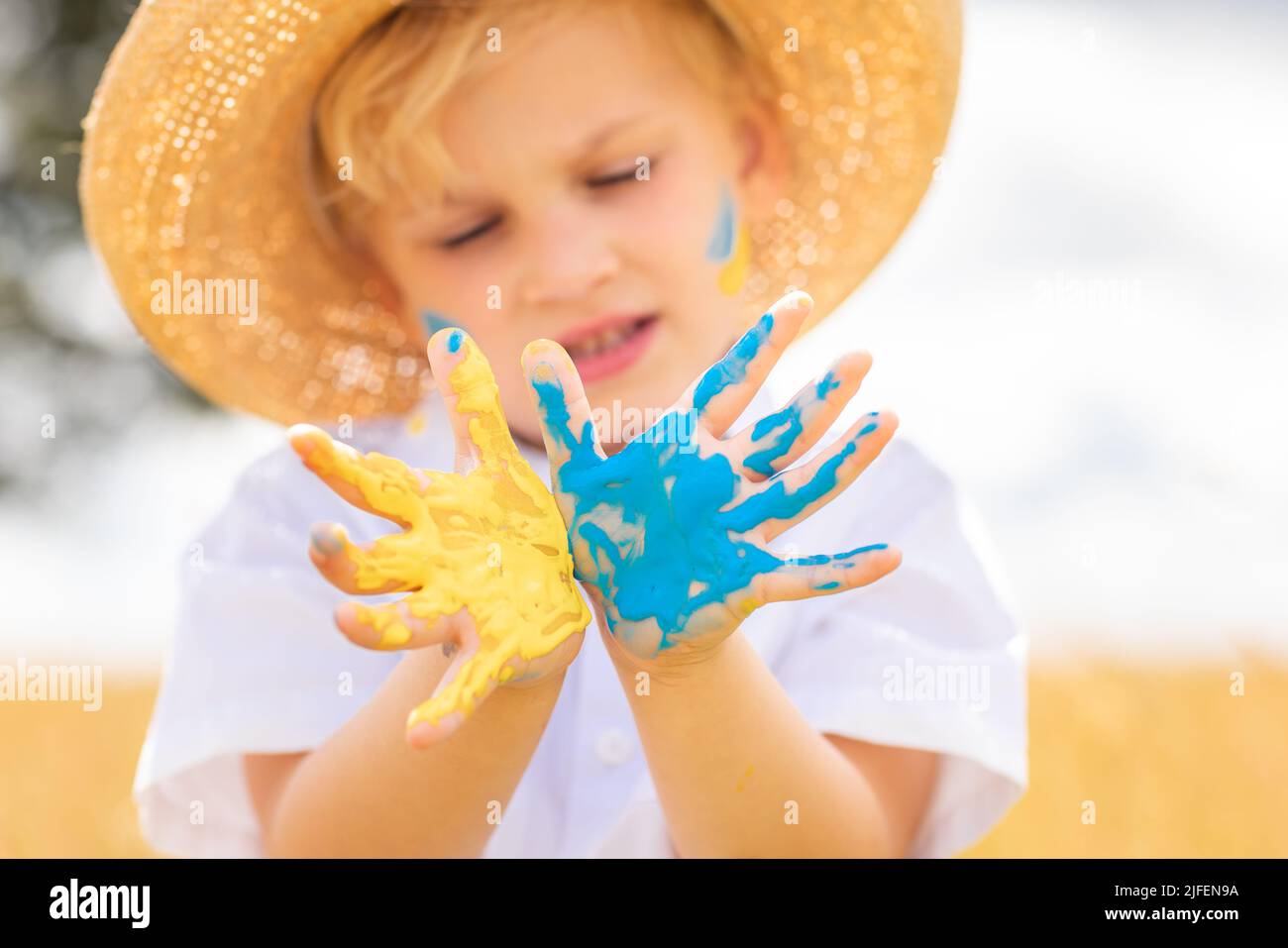 Fermare la guerra in Ucraina. Amore Ucraina concetto. Ragazzo ucraino con bandiera Ukraina- giallo e blu dipinto sulle mani si leva contro la guerra. Foto Stock