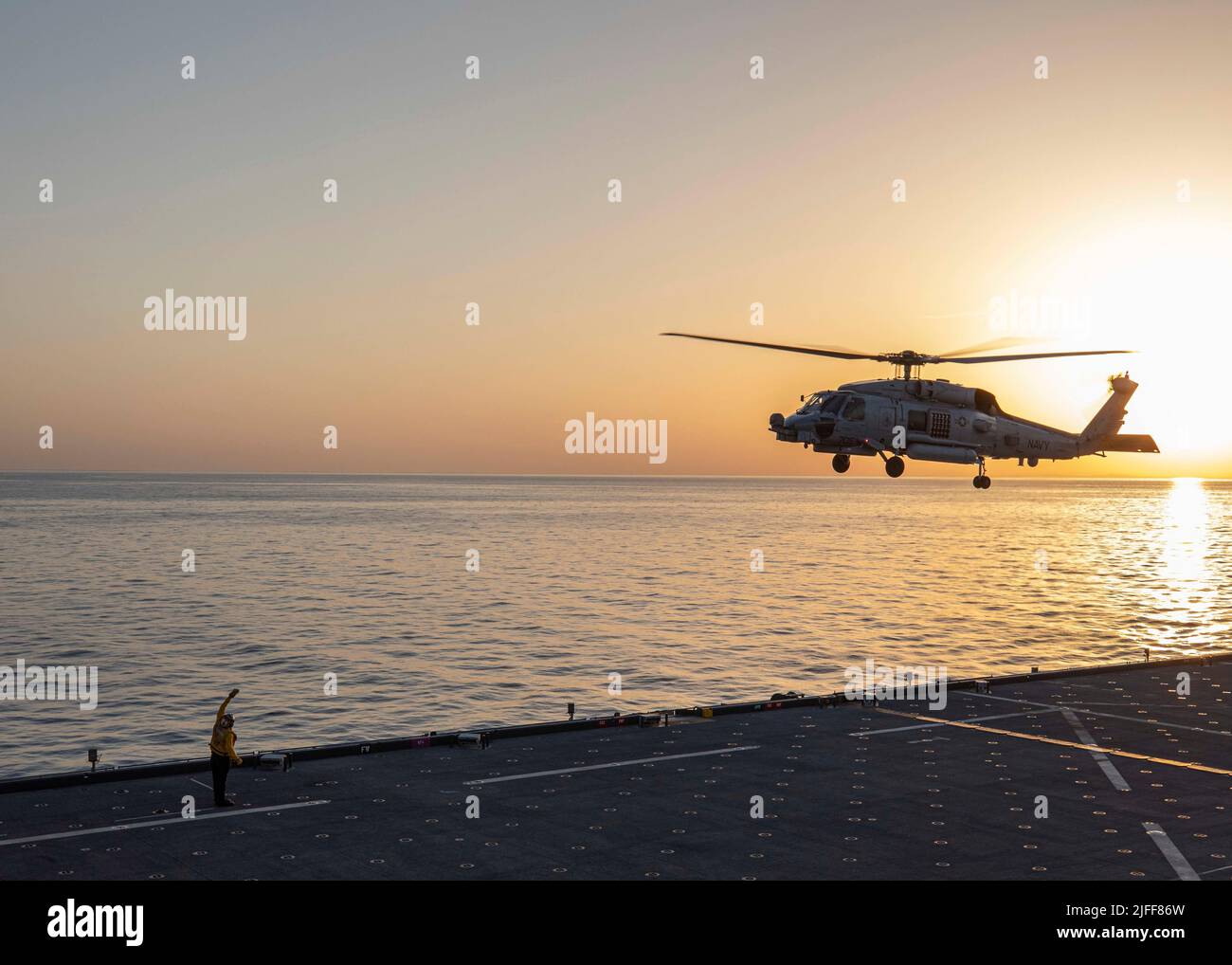220529-N-TI693-2103 MAR MEDITERRANEO (29 maggio 2022) - Aviation Boatswain's Mate (Handling) 1st Classe Michael Duffy, da Philadelphia, segnala un elicottero MH-60R di decollo dal ponte di volo a bordo della base marittima di spedizione di Lewis B. Puller-class USS Hershel 'Woody' Williams (ESB 4) durante l'esercizio Phoenix Express 22, 29 maggio 2022. Phoenix Express 22, condotta dalle forze Navali degli Stati Uniti Africa, è un esercizio marittimo progettato per migliorare la cooperazione tra le nazioni partecipanti al fine di aumentare la sicurezza e la sicurezza marittima nel Mediterraneo. (STATI UNITI Foto Navy di Mass Communication Spe Foto Stock