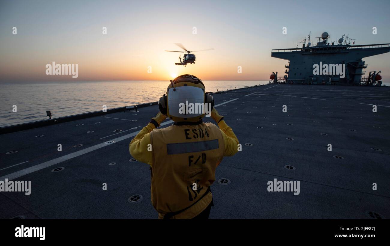 220529-N-TI693-2139 MAR MEDITERRANEO (29 maggio 2022) - Aviation Boatswain's Mate (Handling) 1st Classe Shane Barton, da St. Catherine, Giamaica, guida in un elicottero MH-60R mentre atterrano sulla base marittima di spedizione Lewis B. Puller-class USS Hershel 'Woody' Williams (ESB 4) durante l'esercizio Phoenix Express 22, 29 maggio 2022. Phoenix Express 22, condotta dalle forze Navali degli Stati Uniti Africa, è un esercizio marittimo progettato per migliorare la cooperazione tra le nazioni partecipanti al fine di aumentare la sicurezza e la sicurezza marittima nel Mediterraneo. (STATI UNITI Foto Navy di Mass Communication Specialist 1st Foto Stock