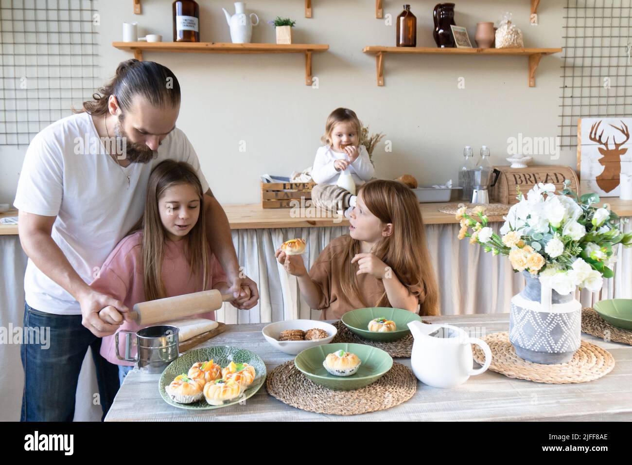 Una famiglia con tre bambini ha divertimento cuocere insieme.papà e figlia Laughing e cucinare cibo sano Vista anteriore concetto di stile di vita . Candidi Foto Stock