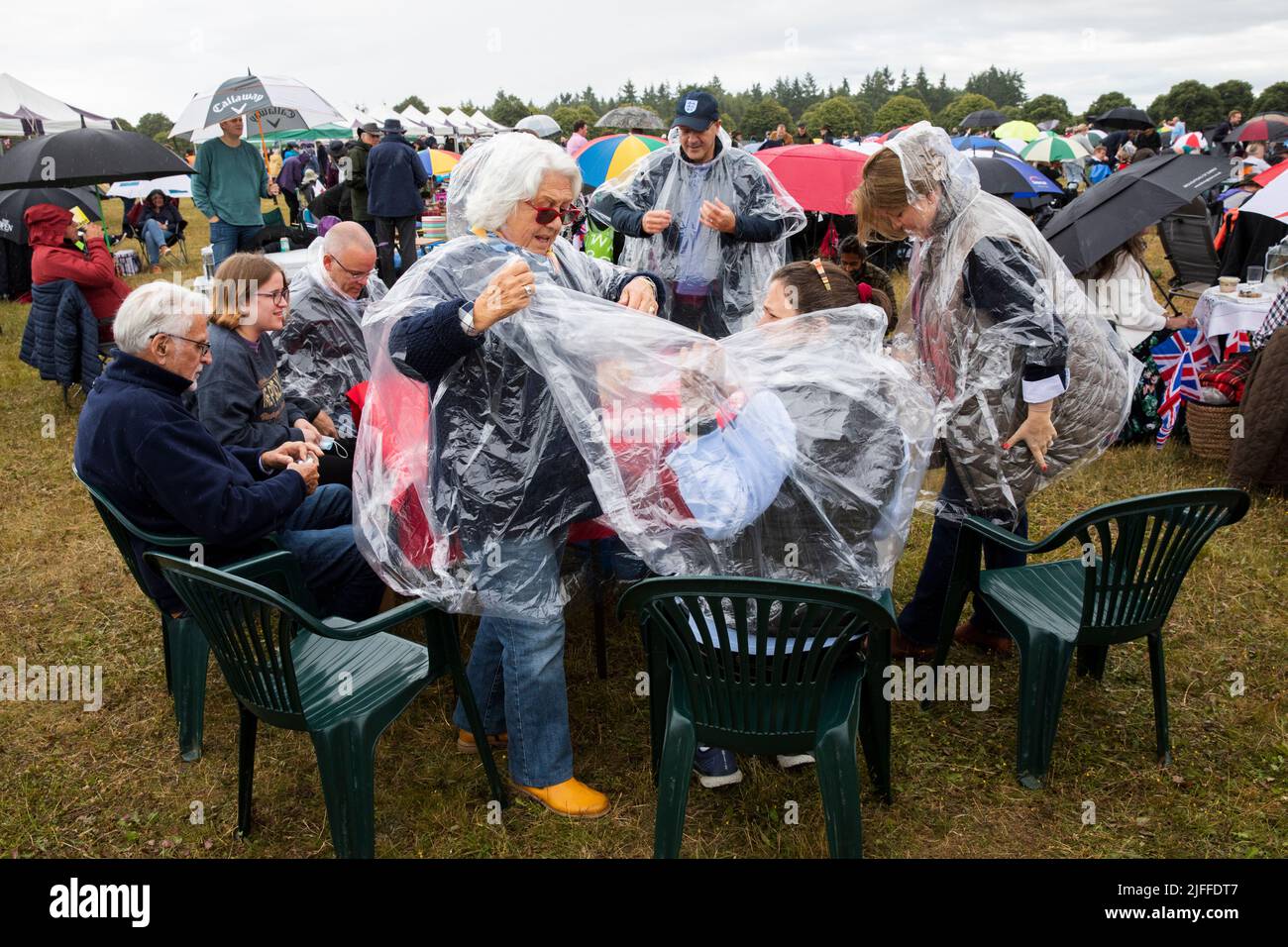 Woodstock, Oxfordshire, Regno Unito. 2nd luglio 2022. Due donne che mettono su un poncho pioggia usa e getta. Concerti picnic di Battle Prom. Palazzo di Blenheim. Regno Unito. Credit: Alexander Caminada/Alamy Live News Foto Stock