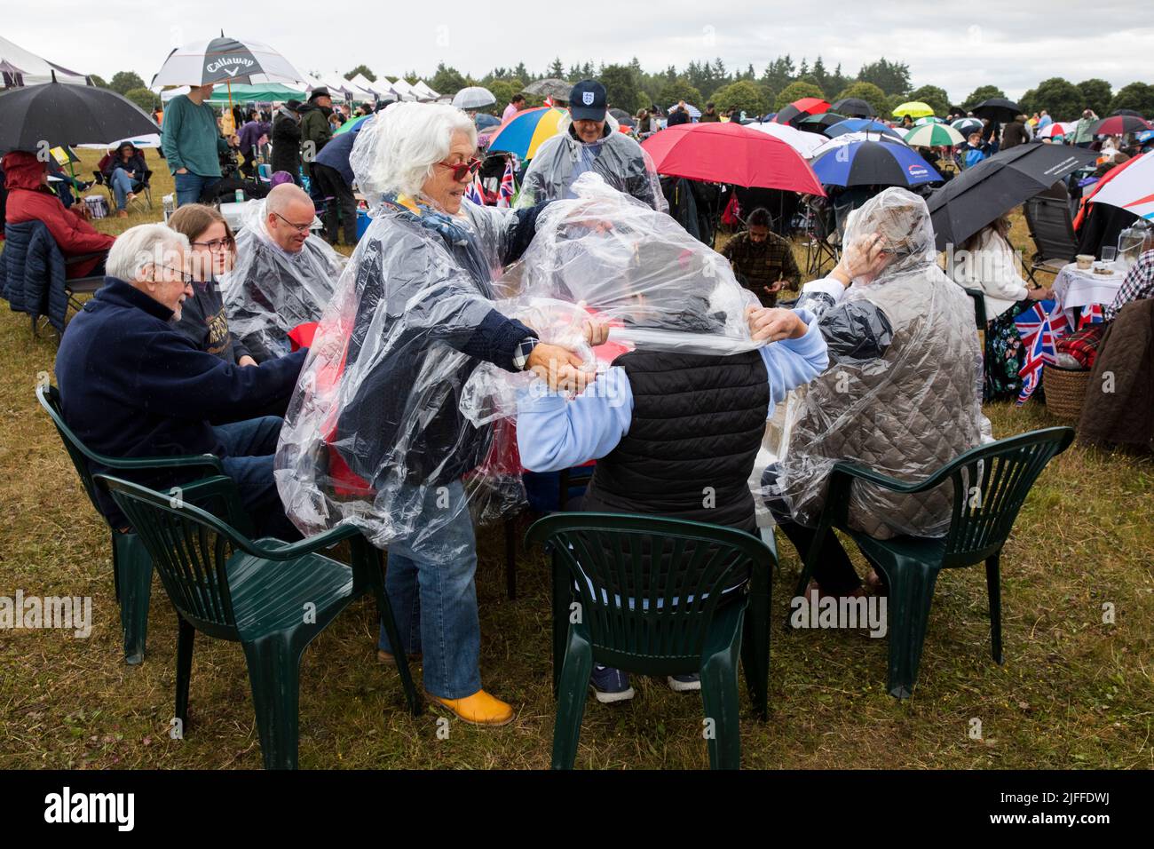 Woodstock, Oxfordshire, Regno Unito. 2nd luglio 2022. Due donne che mettono su un poncho pioggia usa e getta. Concerti picnic di Battle Prom. Palazzo di Blenheim. Regno Unito. Credit: Alexander Caminada/Alamy Live News Foto Stock