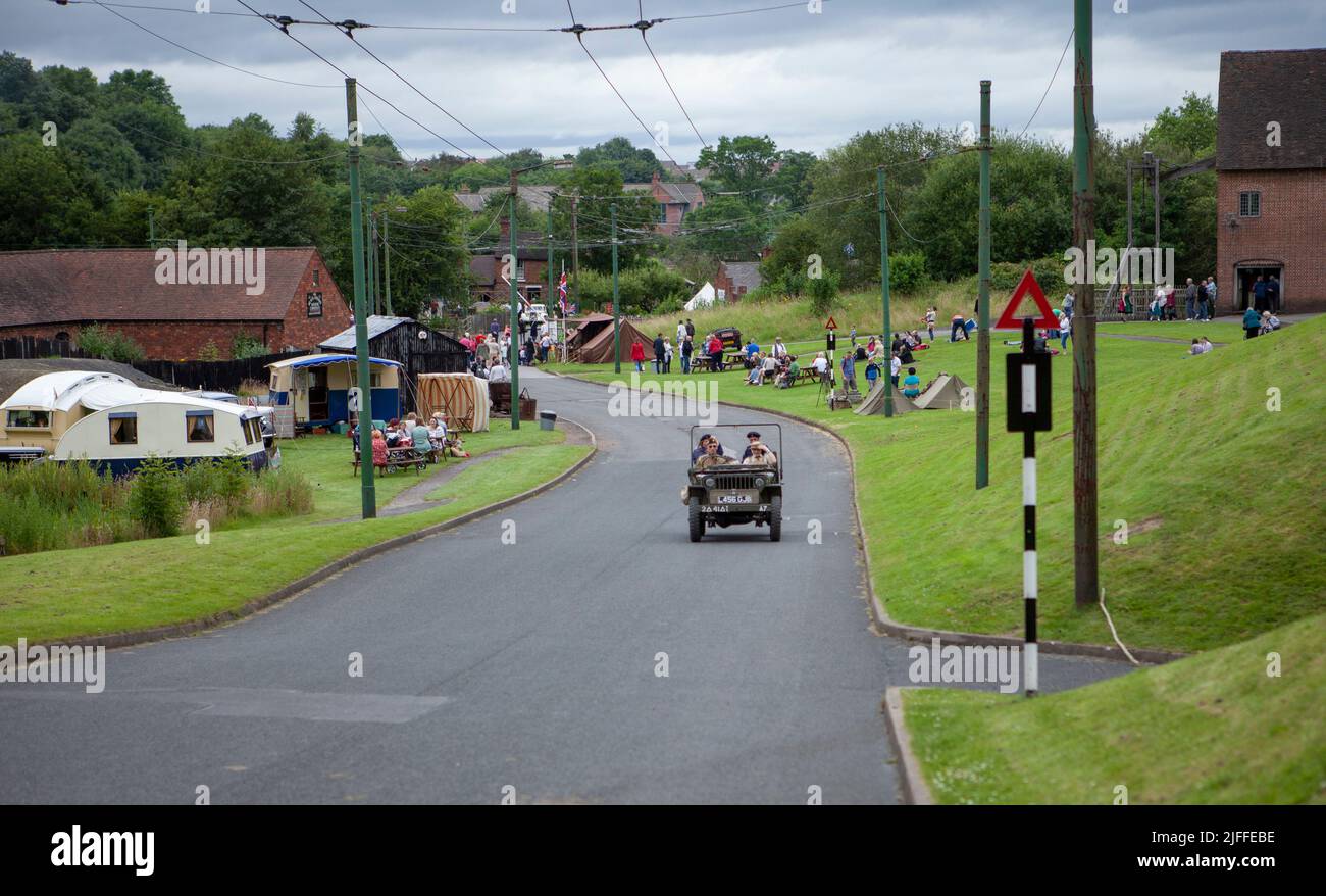 una jeep dell'esercito che viaggia su strada durante una rievocazione degli anni '40 Foto Stock