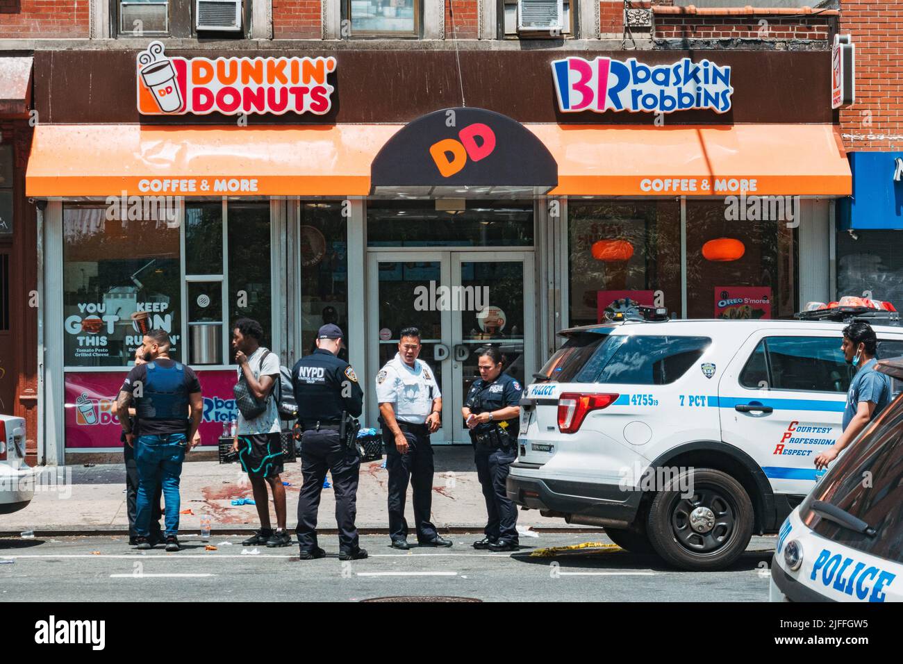 2 luglio 2022: Gli ufficiali NYPD parlano con un membro del pubblico di fronte alla scena di un tiro nel Lower East Side di Manhattan, New York Foto Stock