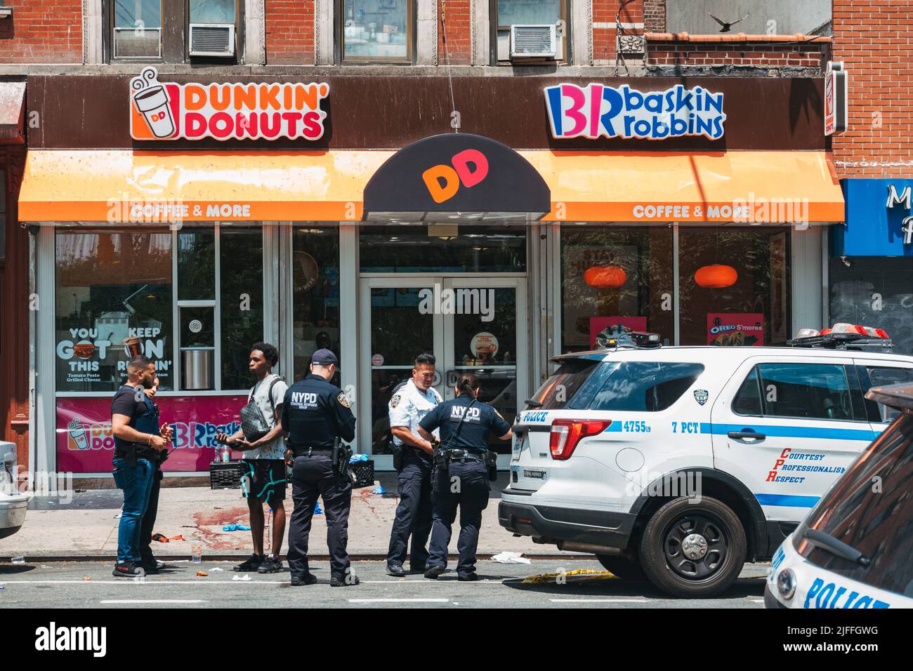 2 luglio 2022: Gli ufficiali NYPD parlano con un membro del pubblico di fronte alla scena di un tiro nel Lower East Side di Manhattan, New York Foto Stock