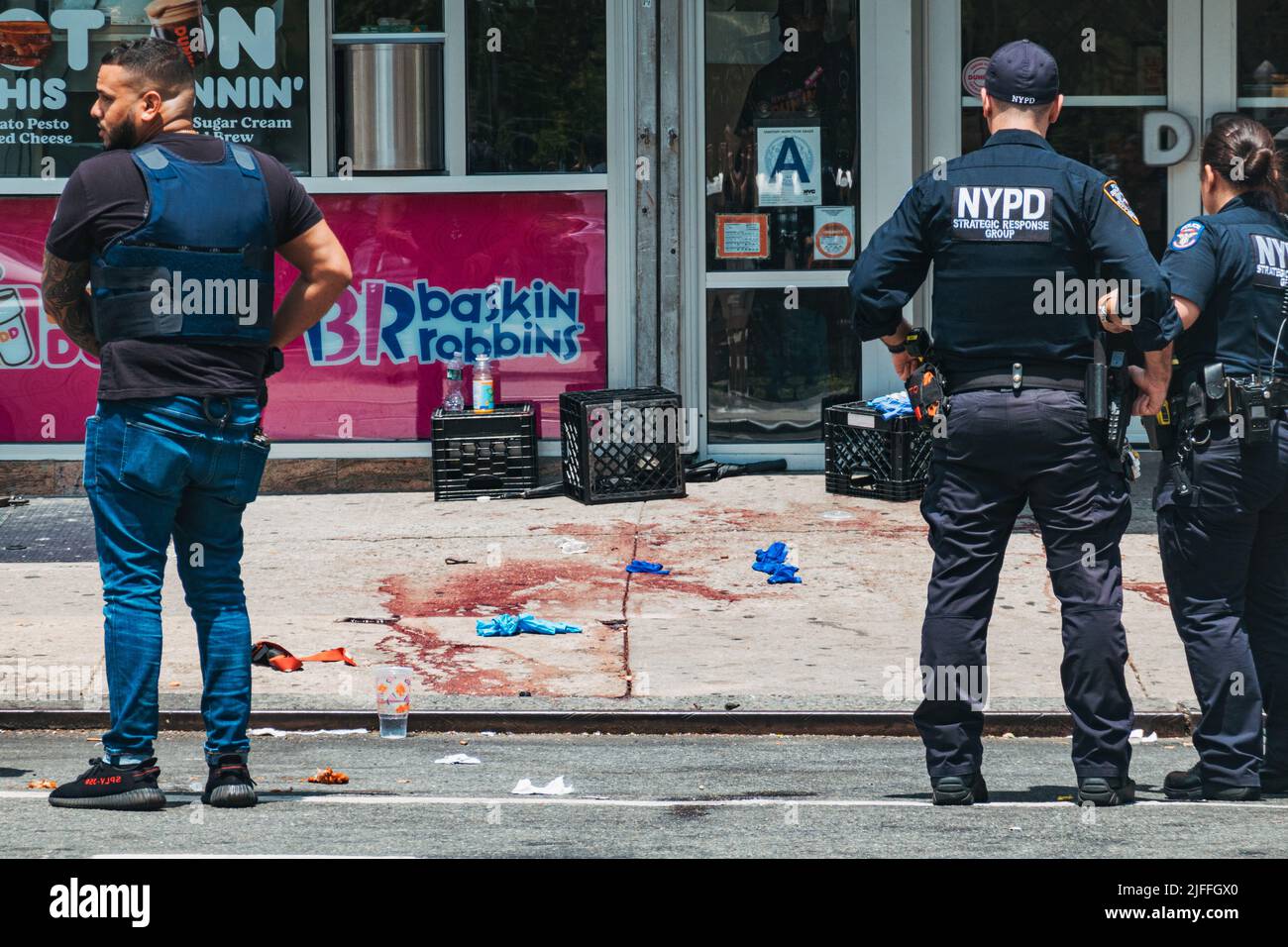 2 luglio 2022: Gli ufficiali NYPD parlano con un membro del pubblico di fronte alla scena di un tiro nel Lower East Side di Manhattan, New York Foto Stock