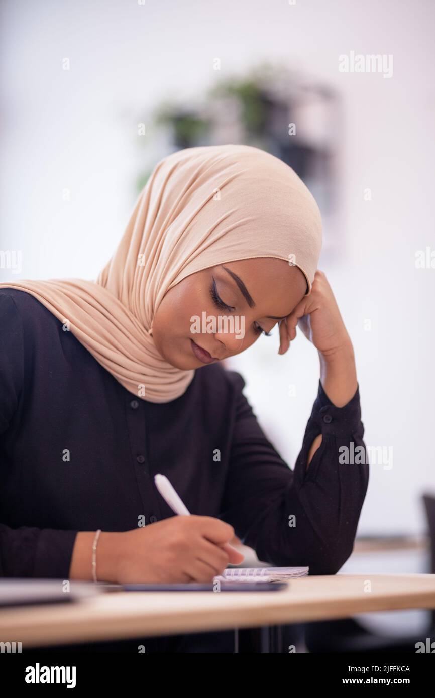 Studenti che fanno un test in classe. Giovani ragazze musulmane intelligenti con hijab che frequenta la classe in college. Foto Stock