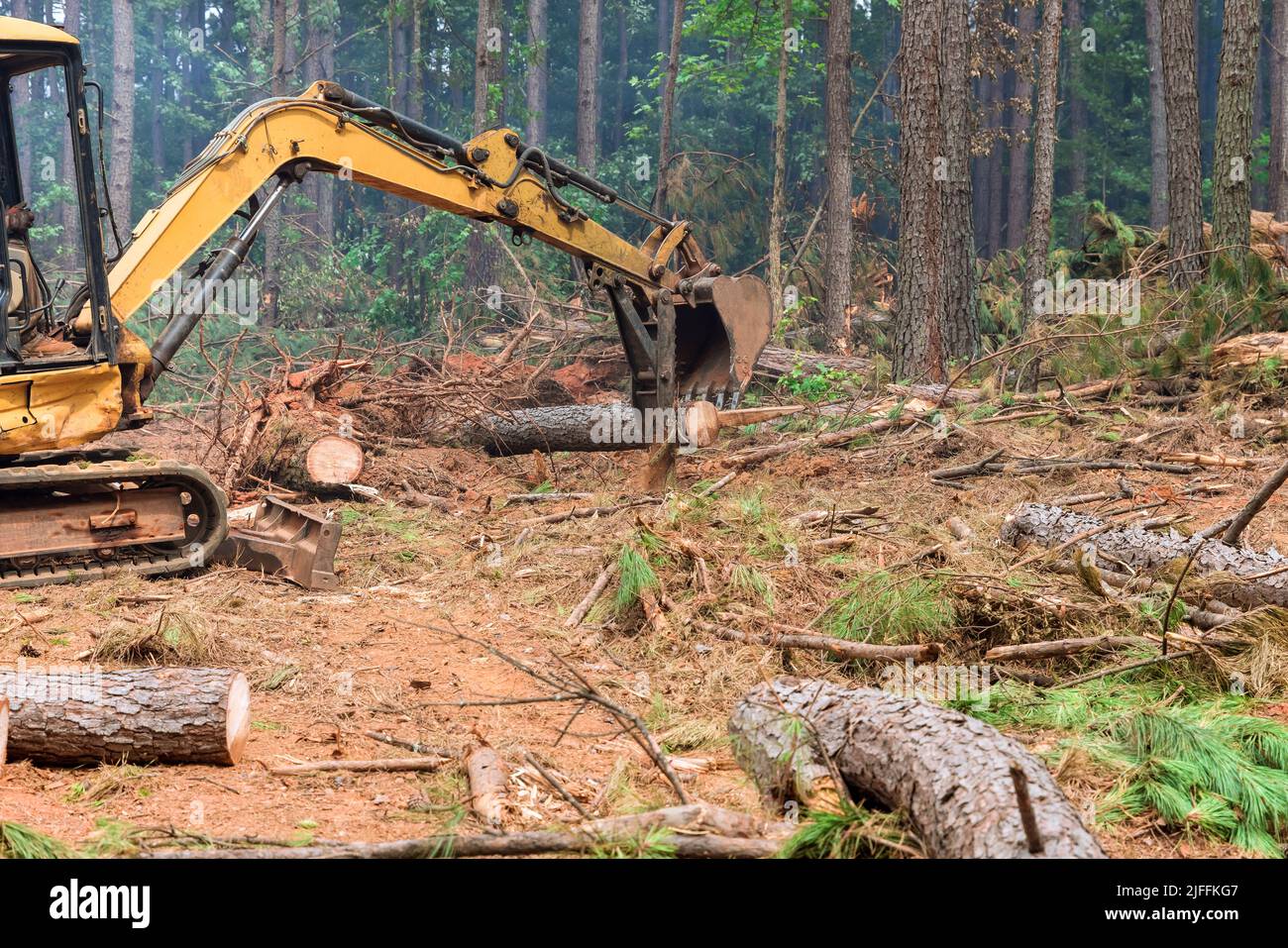 Il lavoro viene eseguito su un manipolatore del trattore che solleva i log nelle foreste Foto Stock
