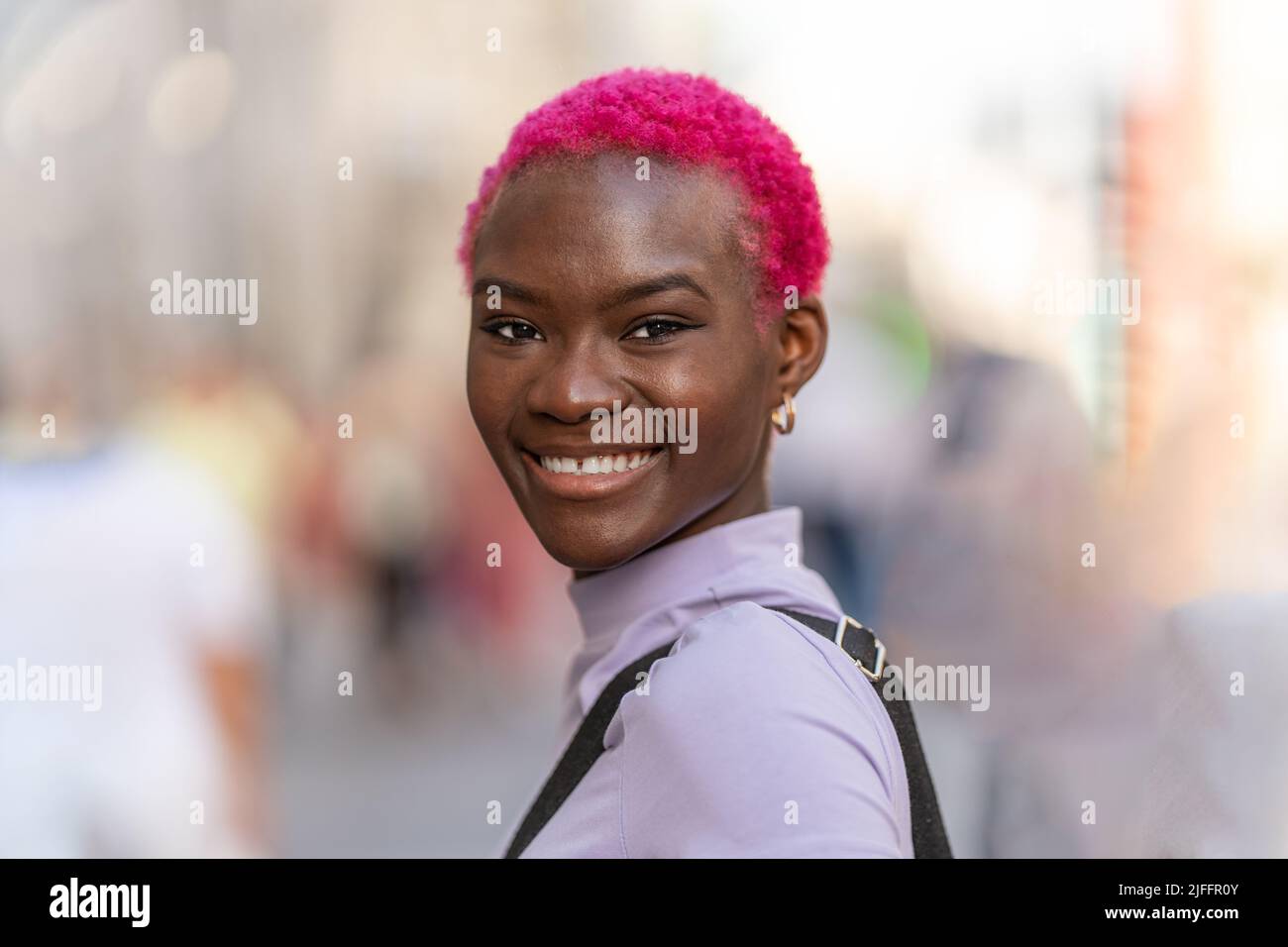 Donna moderna e giovane sorridente alla macchina fotografica Foto Stock