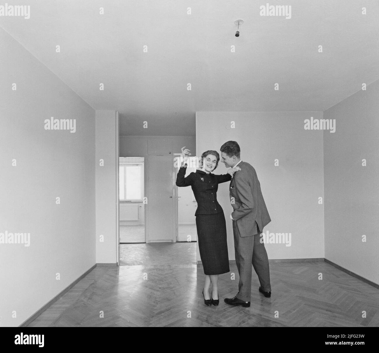 Nel 1950s. Una giovane coppia raffigurata nel loro nuovo appartamento. Sta osservando creativa e positiva con le idee come decorare. Il suo linguaggio del corpo suggerisce che è più riservato e non così spontaneo. Svezia 1957. Foto Stock