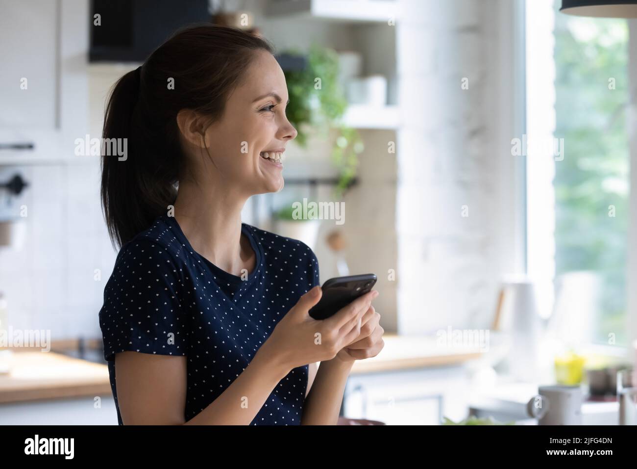 Entusiasta felice utente di smartphone donna che tiene il telefono cellulare Foto Stock