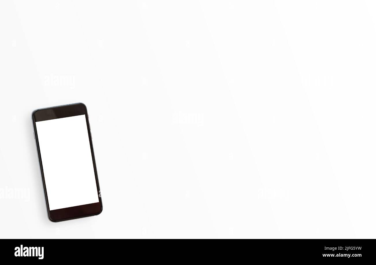 Tavolo da lavoro bianco minimale con smartphone su sfondo bianco. Vista dall'alto con spazio per la copia di testo o foto. Foto Stock
