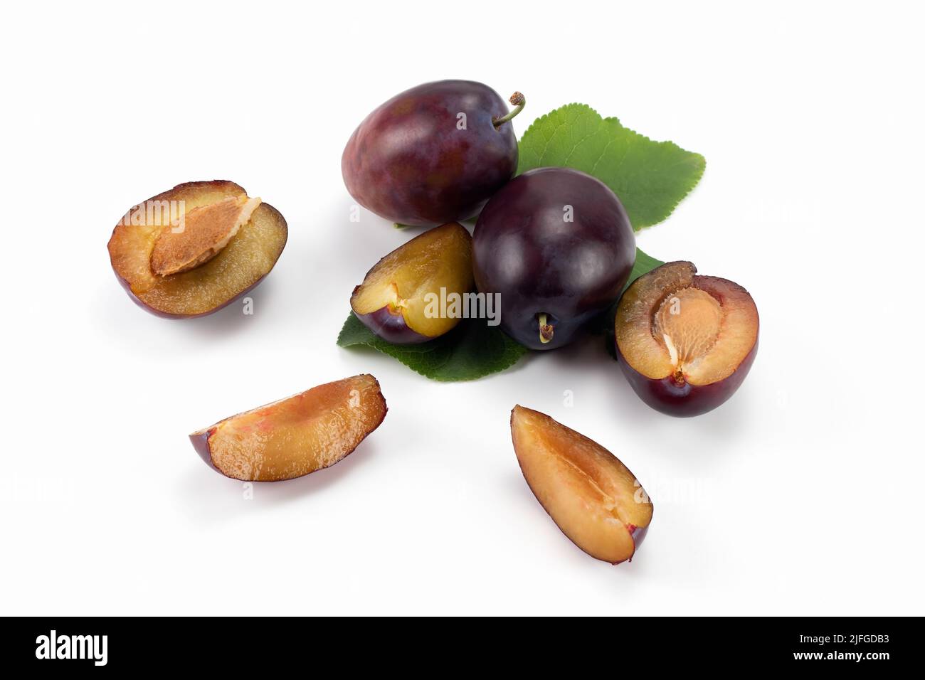 Saporite prugne. Frutti di prugna freschi isolati su sfondo luminoso, tagliati a fette e interi. Vista ravvicinata. Foto Stock