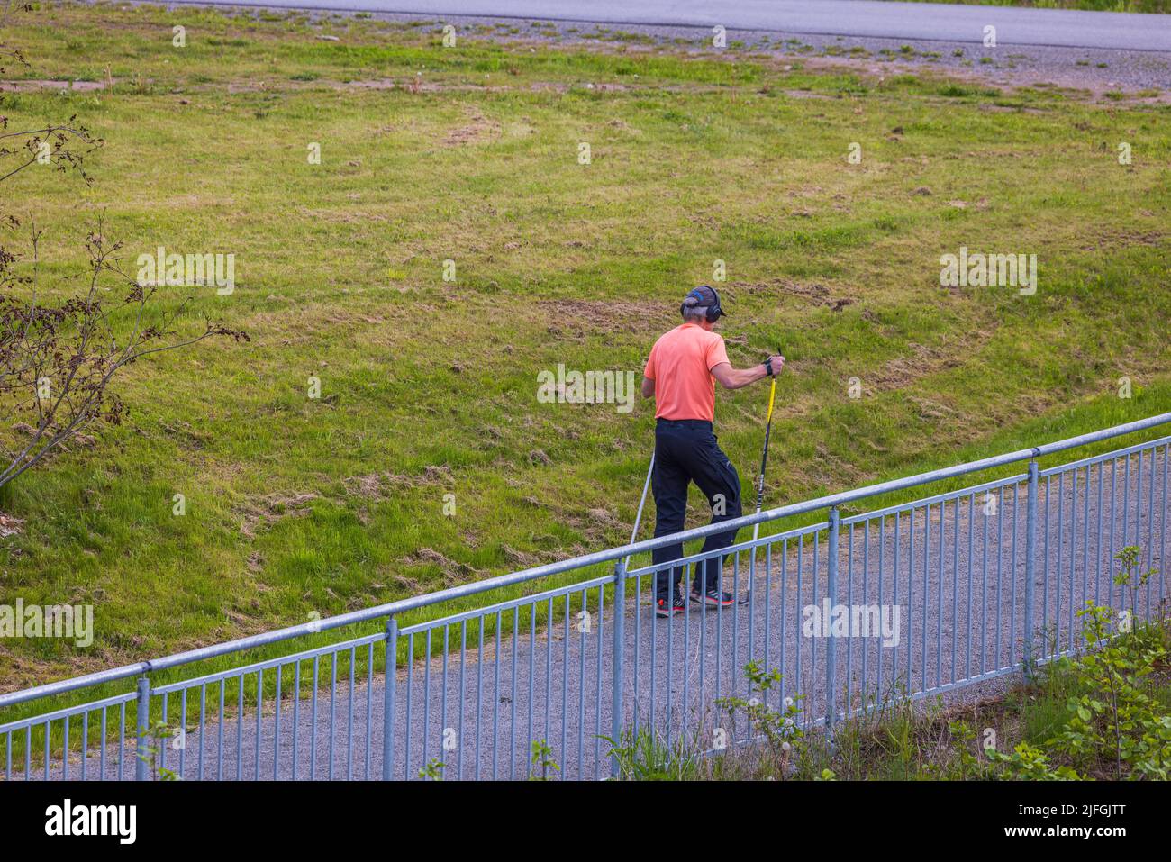 L'uomo cammina nordic walking con i bastoni lungo il lungofiume. Svezia. Foto Stock