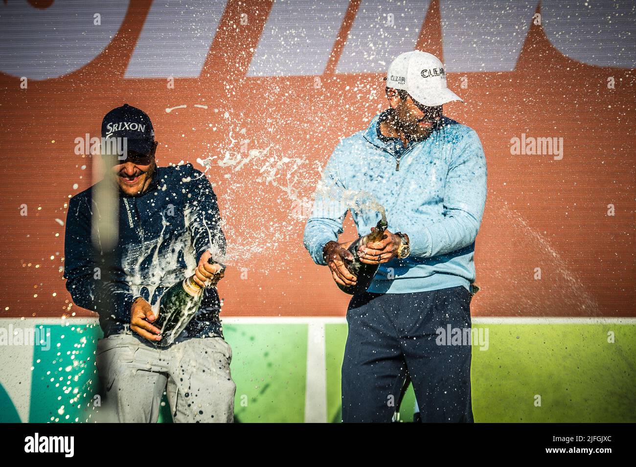 Charl Schwartzel a cui si unisce Hennie Du Plessis è la celebrazione dello champagne spruzzato dopo la presentazione del trofeo al LIV Golf Invitational London Foto Stock