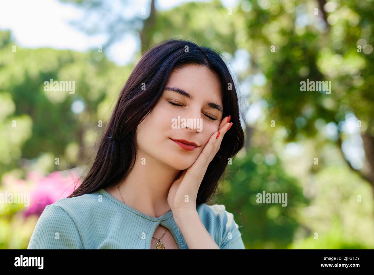 Giovane donna caucasica che indossa il tee in piedi sul parco della città, all'aperto toccando la bocca con la mano con espressione dolorosa a causa di mal di denti o illn dentale Foto Stock