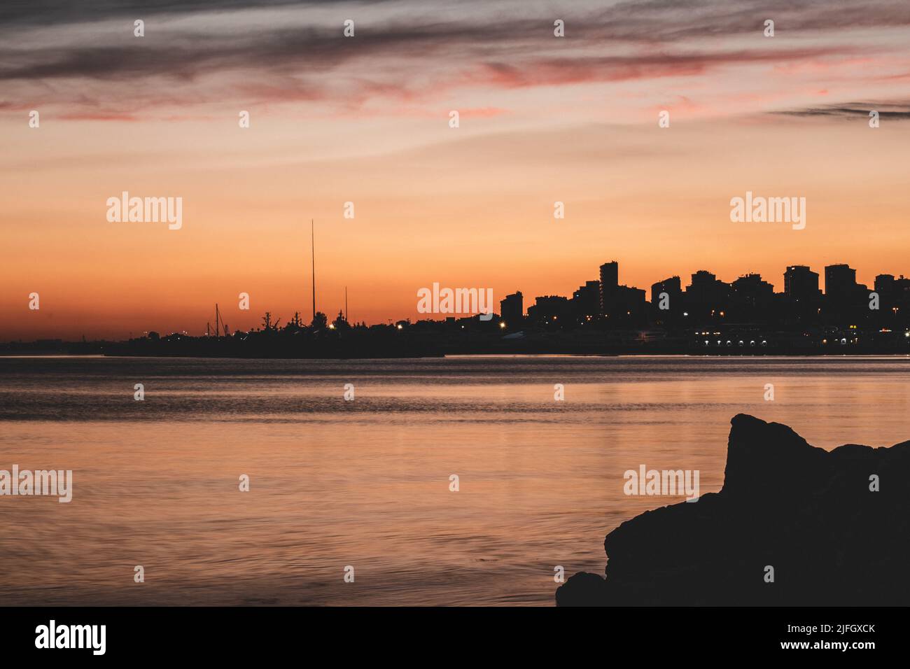 tramonto sulla città - tonalità arancioni nel cielo Foto Stock