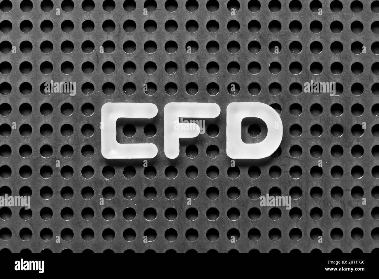 Lettera alfabetica bianca in parola CFD (abbreviazione di Contract for Difference) su sfondo nero di pegboard Foto Stock