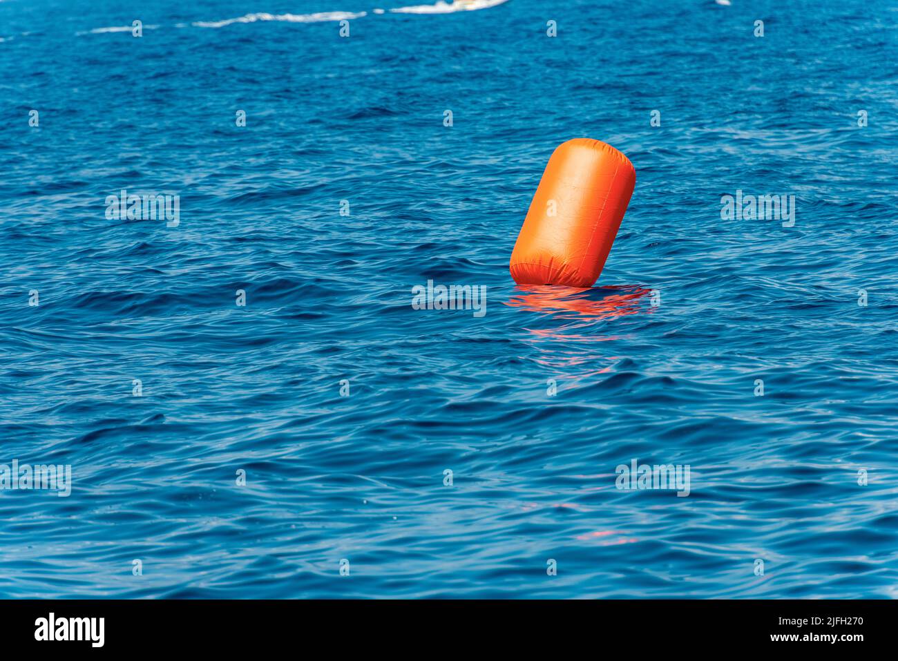 Una grande boa gonfiabile arancione galleggiante nel blu del Mediterraneo, Golfo di la Spezia, Liguria, Italia, Europa. Foto Stock