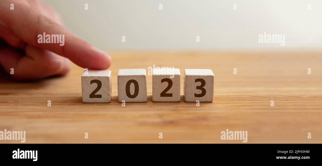 2023 concetto di felice anno nuovo. 2023 numero su cubo di legno con dito per mostrare il numero 2. Nuova coppia, matrimonio, piano, affari, carriera, obiettivo, successo. G Foto Stock