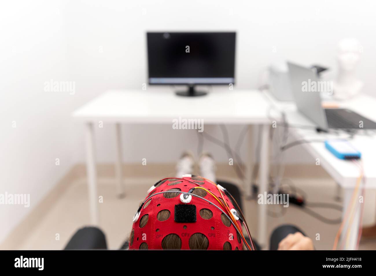 Copricapo di una ragazza che controlla i segnali di impulso durante una sessione di biofeedback Foto Stock