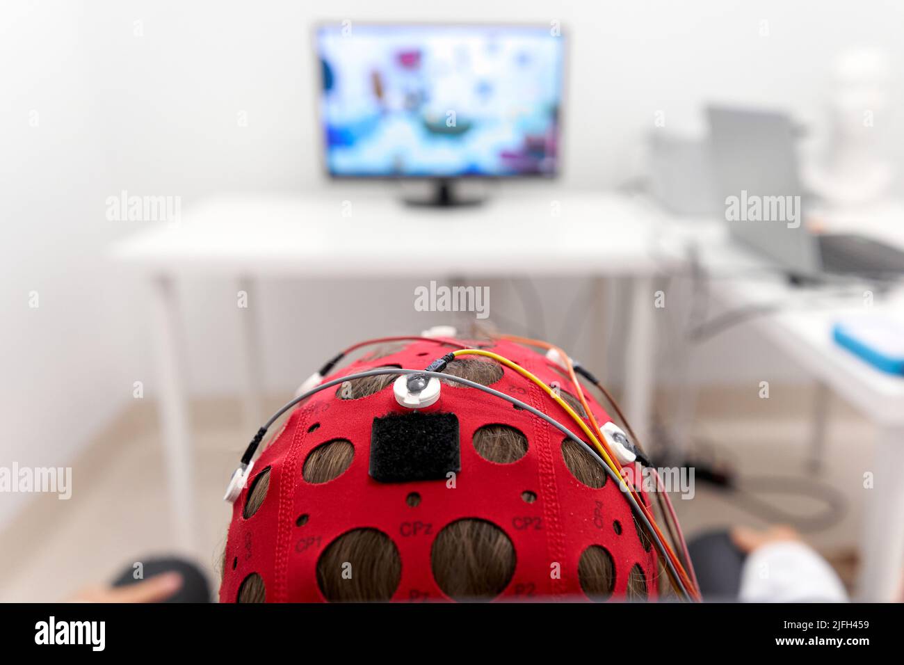 Copricapo di una ragazza che monitora i segnali di impulso durante una sessione di biofeedback Foto Stock