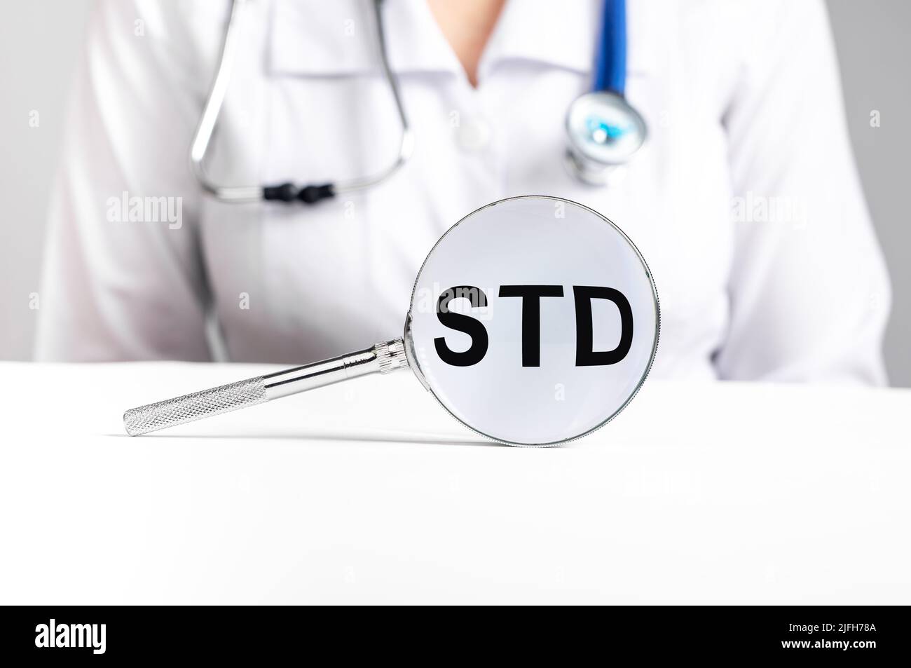 Acronimo STD, malattia medica attraverso la lente di ingrandimento. Foto di alta qualità Foto Stock