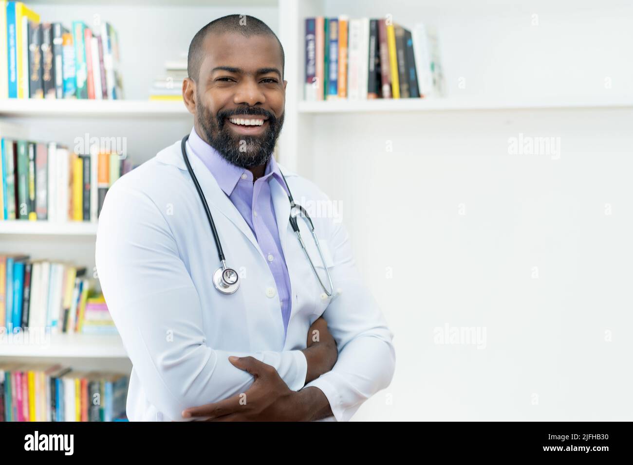 Ridendo medico afroamericano con barba e stetoscopio presso l'ufficio dell'ospedale Foto Stock