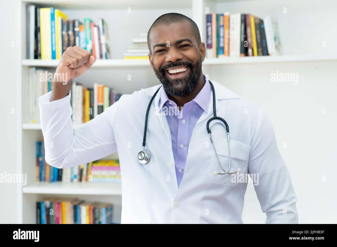 Acclamare il medico afroamericano con la barba e lo stetoscopio presso l'ufficio dell'ospedale Foto Stock