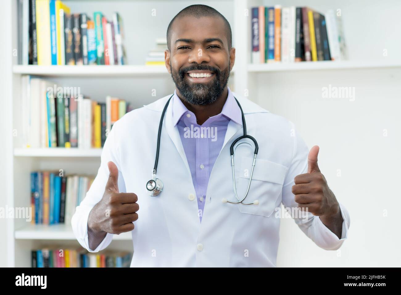 Ottimista medico afroamericano con barba e stetoscopio in ospedale Foto Stock