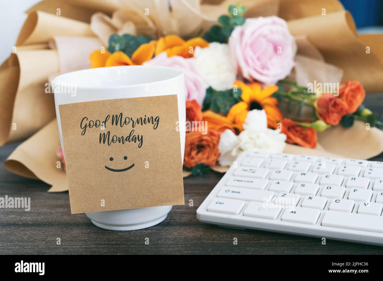 Buongiorno Lunedi saluto su una nota adesiva con una tazza di caffè Foto Stock