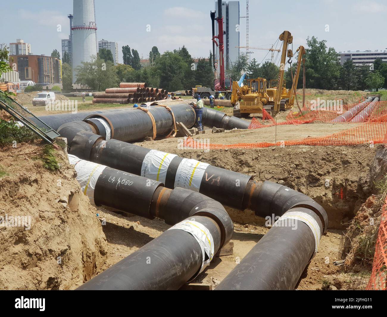 Sito di ricostruzione della pipeline dell'impianto di teleriscaldamento e sostituzione di vecchie tubazioni con nuove. Posa di tubi di riscaldamento in una trincea a costruzione s. Foto Stock