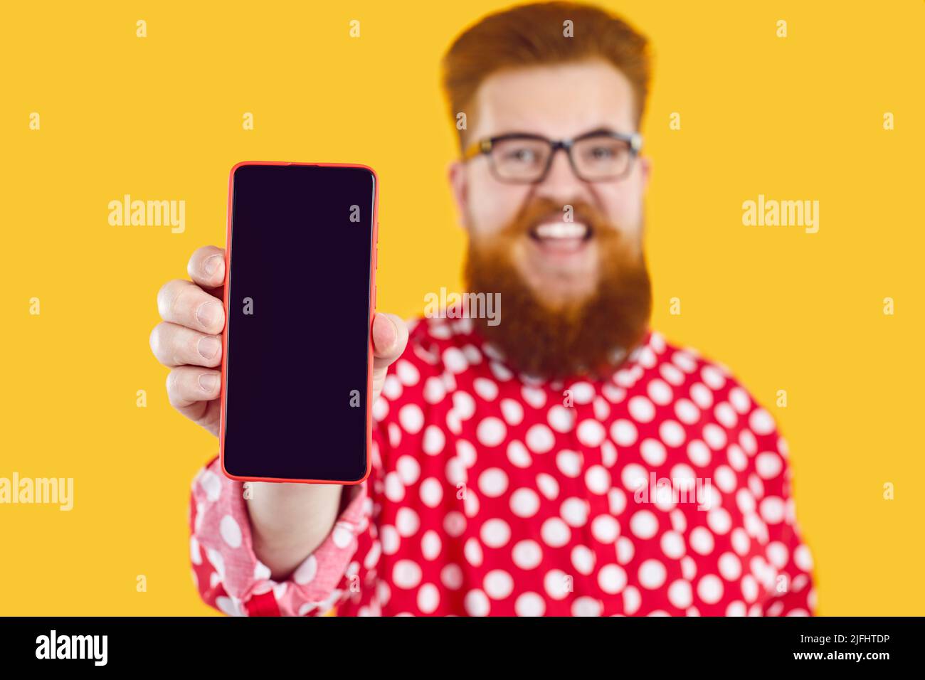 Happy divertente Fat uomo mostra schermo del telefono cellulare presentare applicazione, offerta o sito web mobile. Foto Stock
