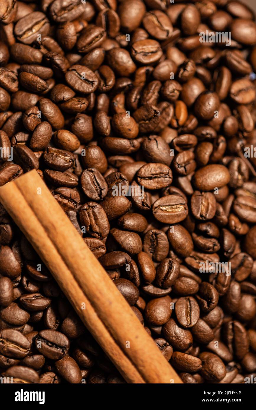 Chicchi di caffè arrosto e un bastone di cannella. Fondo chicchi di caffè Foto Stock