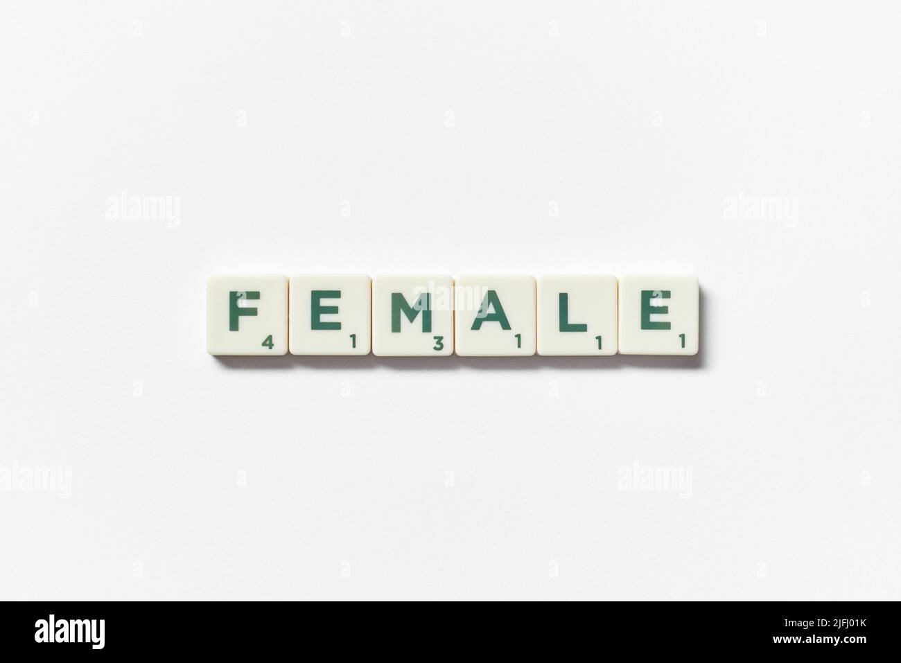 Femmina formata da elementi scrabble su sfondo bianco. Foto Stock