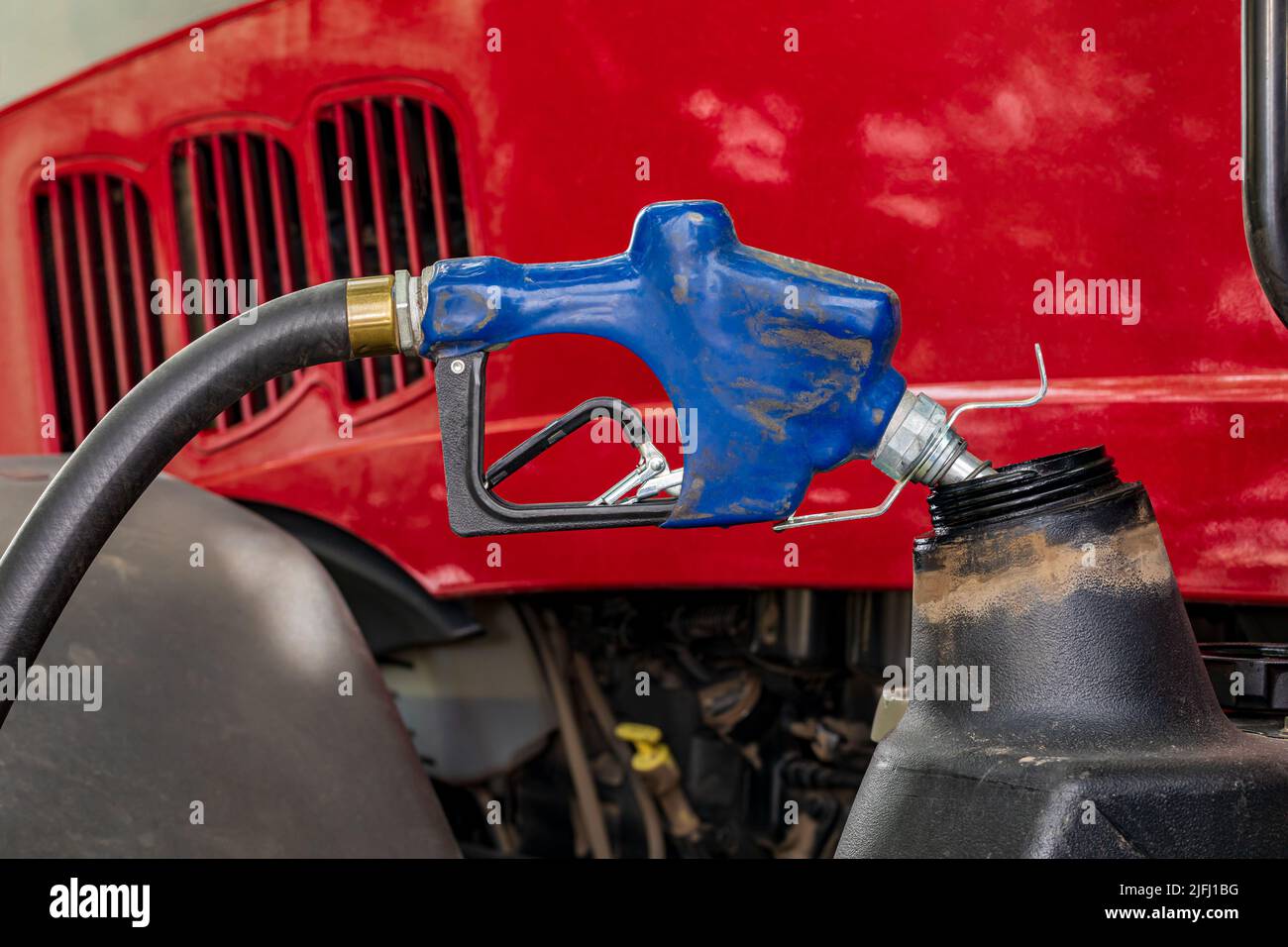 Ugello carburante diesel per alimentare il trattore agricolo. Costi di produzione agricola, aumento del prezzo del carburante e concetto di inquinamento da emissioni. Foto Stock