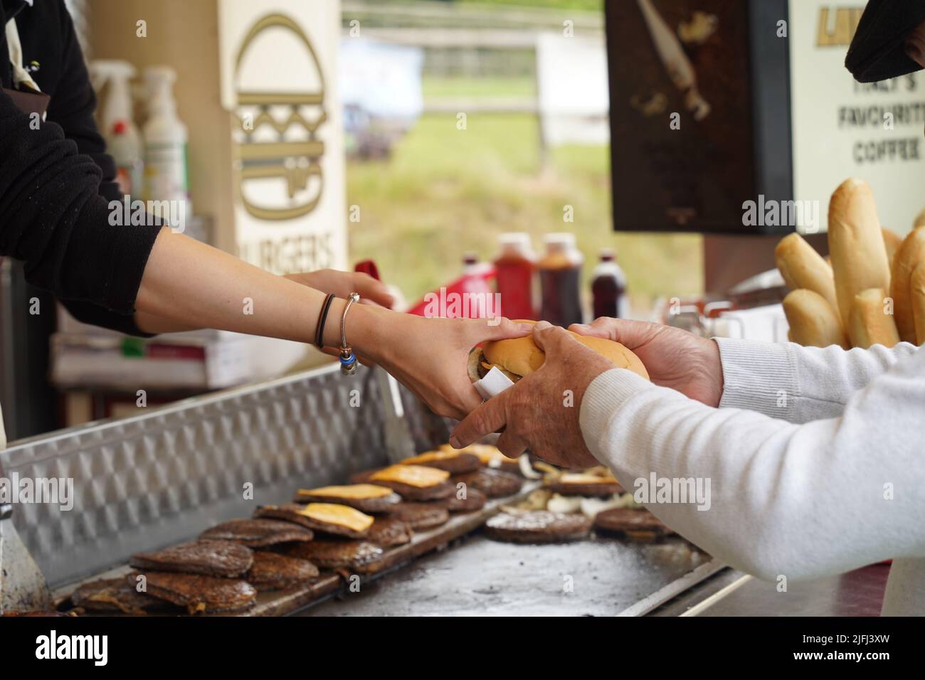 Cibo caldo (fast food) che vende cheeseburgers appena cucinati Foto Stock
